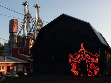 Neon installation in front of a barn